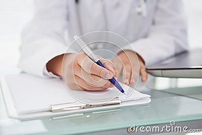 Doctor writing down medical notes Stock Photo