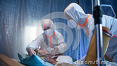 Doctors and covid-19 patient with oxygen mask in bed in hospital, coronavirus concept. Stock Photo