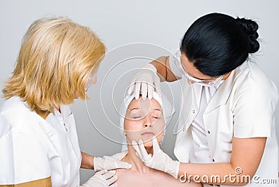 Doctors examine woman face skin Stock Photo