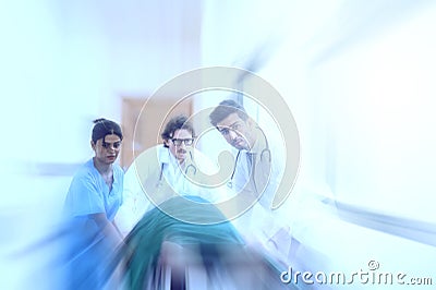 Doctors, Nurses, and Paramedics pushing stretcher gurney bed with seriously injured patient towards the operating room. Stock Photo