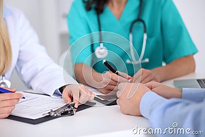 Doctors and patient are discussing something, just hands at the table Stock Photo