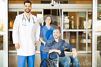 Doctors and patient in hospital entrance Stock Photo