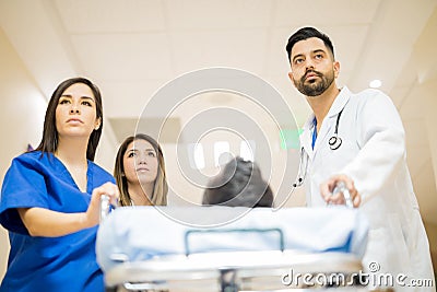 Doctors pushing stretcher with a patient Stock Photo