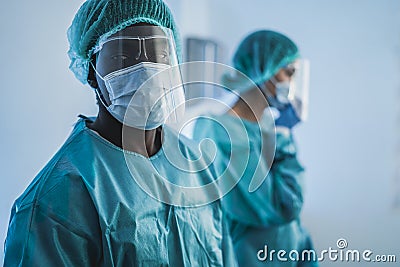Doctors at work inside hospital during coronavirus outbreak - Medical worker on Covid-19 crisis wearing safety protective mask - Stock Photo