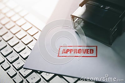 Document with approved stamp on computer keyboard Stock Photo
