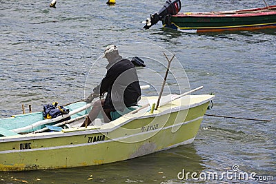 Documentary editorial image. Fisherman on small wood boat Editorial Stock Photo