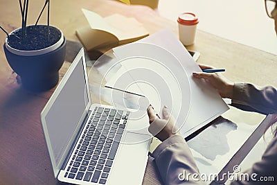 Documents paper sheet in loft office, working on laptop computer. Team working, business people. Space for design layout. Stock Photo