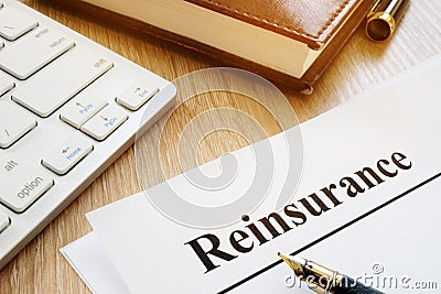 Documents with title reinsurance on a desk. Stock Photo