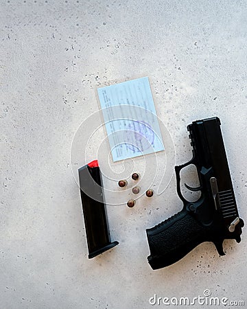 A handgun with bullets symbolizing gun rights while framed against the United States constitution. Stock Photo