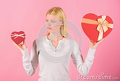 Does size really matter. Woman hold big and little heart shaped gift boxes. Which one she prefer. Girl decide which gift Stock Photo