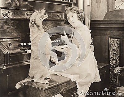 Dog accompanying woman on piano Stock Photo