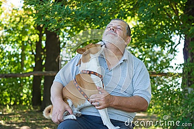 Dog is ready for to lick bearded Caucasian man while sittimg on the master hands Stock Photo