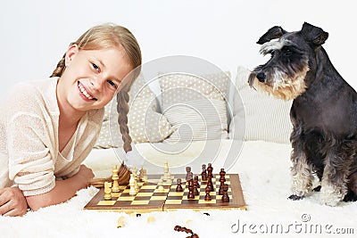 The dog teaches the child to play chess. Stock Photo