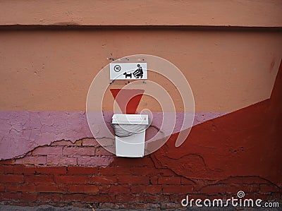 Dog waste basket with a sign saying you must clean up after your dog using dog poop bags Stock Photo