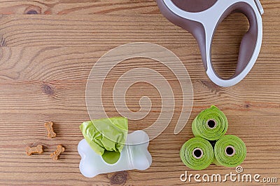 Dog wolking equipment, leash, poop bags and treats on wooden background, flat lay Stock Photo