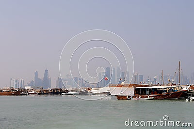 Traditional dhows moored up along the corniche in the Qatari capital Doha, with the skyscrapers Editorial Stock Photo