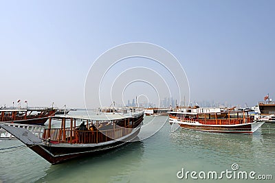 Traditional dhows moored up along the corniche in the Qatari capital Doha, with the skyscrapers Editorial Stock Photo