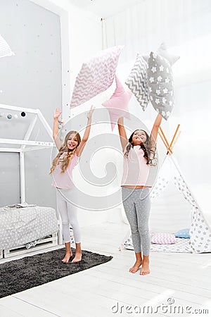 Doing whatever they want. Sleepover party ideas. Sisters play pillows bedroom party. Pillow fight pajama party. Girls Stock Photo