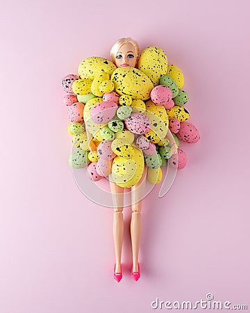 Doll with colorful Easter eggs on pastel pink background. Minimal spring holidays concept Editorial Stock Photo