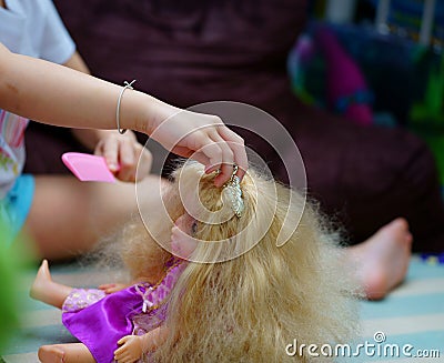 Doll hair comb by girl Editorial Stock Photo