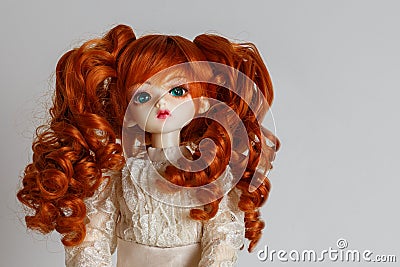 A doll with lush red hair in an antique dress Stock Photo