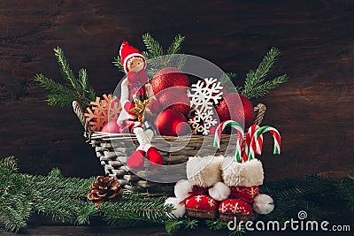 Doll sitting in a basket with fir tree branches, red balls and s Stock Photo