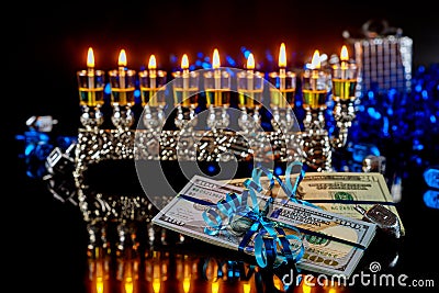 Dollar bill, cash gift with burning menorah for Hanukkah Stock Photo