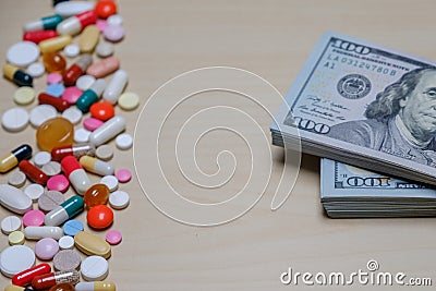 Dollar bills and colored pills on a light background. Tablets money concept. Stock Photo