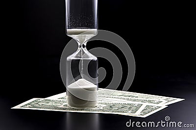 Dollar bills lie near the hourglass. Time is money. The salary. Business solutions in time. Hourglass time measurement Stock Photo
