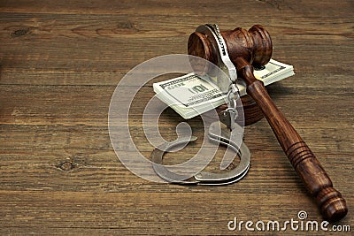 Dollar Cash, handcuffs and judge gavel on wood table Stock Photo