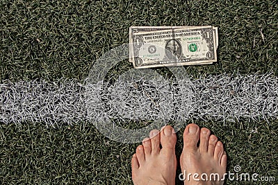 dollar lies near the strip on the grass and near the bare feet of a woman, financial theme, dollar Stock Photo