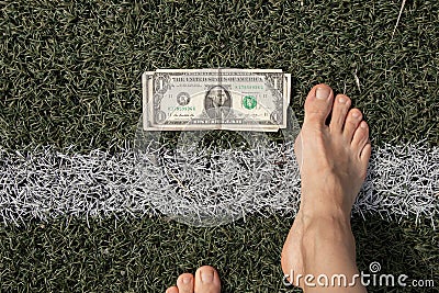 dollar lies near the strip on the grass and near the bare feet of a woman, financial theme, dollar Stock Photo