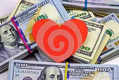 Dollar packs and big red paper heart on money background. Sex, love and prostitution concept. Stock Photo