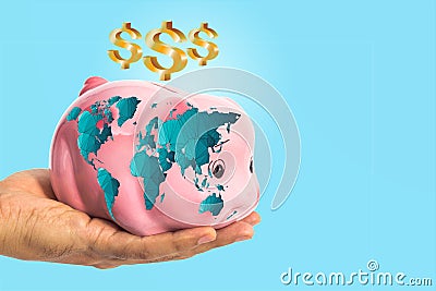 Dollar sign over piggy bank with worldmap in male hand Stock Photo