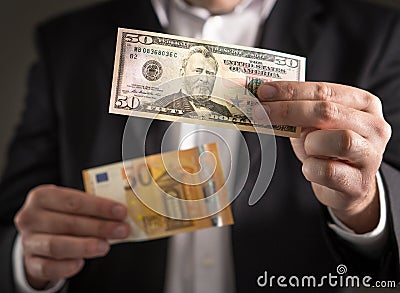 Dollar vs euro. Business man in suit holding 50 banknote Stock Photo