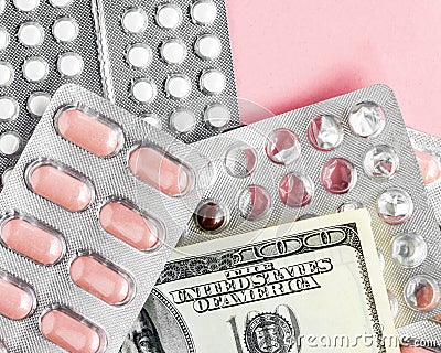 Dollars banknote and pills in blister on a pink background, rising prices of healthcare system. Vaccine and antibiotic for Stock Photo