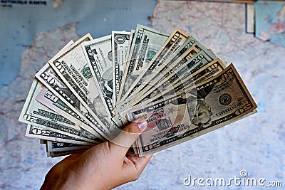 Dollars in the hands. Dollar bills. Cash US currency . Money. Map in the backgraund. Tourism concept Stock Photo