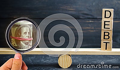 Dollars and the inscription `Debt` are on the scales. Concept of financial crisis and problems. Risk management concept. Payment o Stock Photo