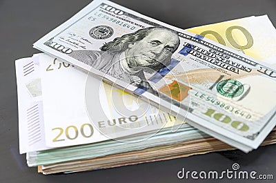 Dollars on a stack of euros. Much money. Black background . Business concept. Stock Photo