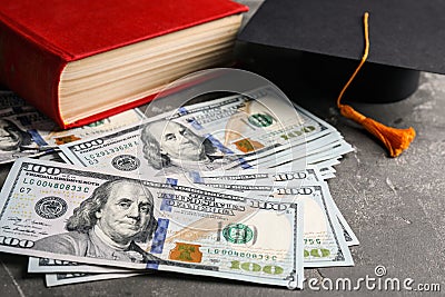 Dollars, student graduation hat and book. Tuition payments concept Stock Photo