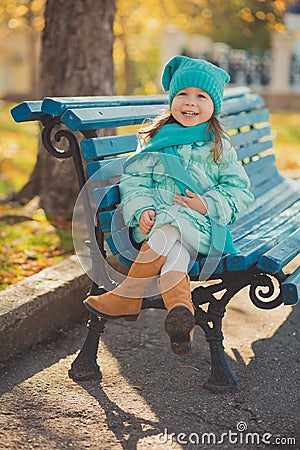 Dolly pin-up toothsome young girl wearing turquoise light blue jacket and warm hat fashion stylish clothes posing in autumn spring Stock Photo