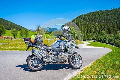 Dolomites Italy - July 2, 2022: Motorcycle with full equipment on the side of a rural mountain alpine road in area of Editorial Stock Photo
