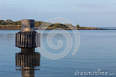 Dolphin pier piling, tube and padded ring mooring in still water, blue sky Stock Photo