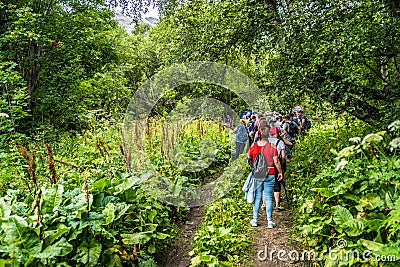 Dombay, Russia 26 July 2020: Group of people go hiking in wooded and hilly area. Editorial Stock Photo