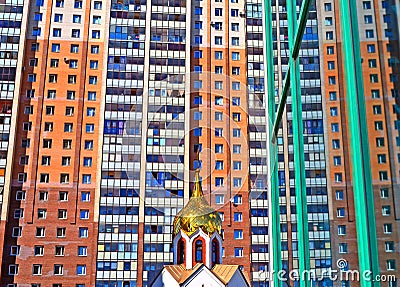 Dome of small church against the big modern building. Stock Photo