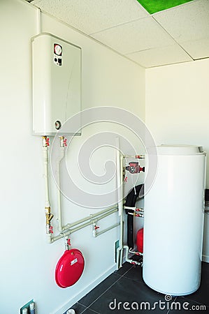 A domestic household boiler room with a new modern gas boiler, heating electric warm water system and pipes Stock Photo