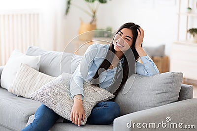 Domestic Portrait. Cheerful Korean Woman Posing On Comfy Couch At Home Stock Photo