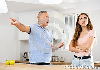 Domestic quarrel between elderly father and adult daughter in kitchen Stock Photo