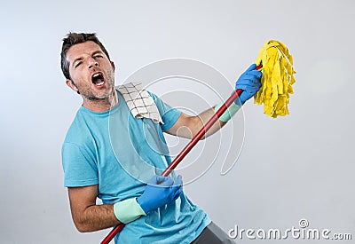 Domestic service man or happy husband cleaning home playing with mop air guitar having fun Stock Photo