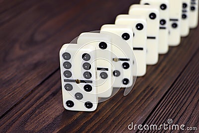 Dominoes game on a wooden table, brown background. Board game domino. Gambling Stock Photo